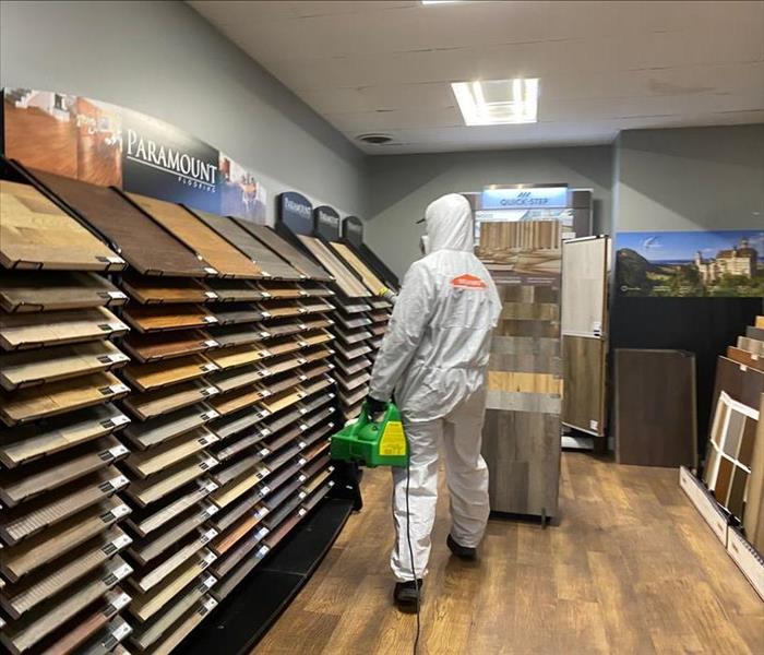 employee in PPE looking at flooring.