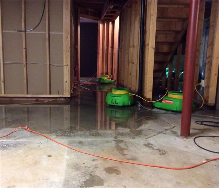 Concrete flooring with three green air movers. 