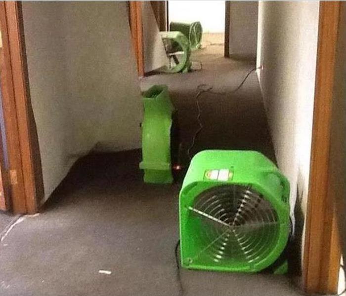 Four air movers placed on the hallway of an office building